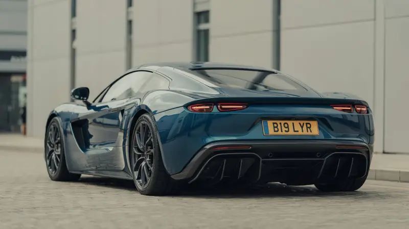 Blue sports car seen from behind wearing the registration B19 LYR
